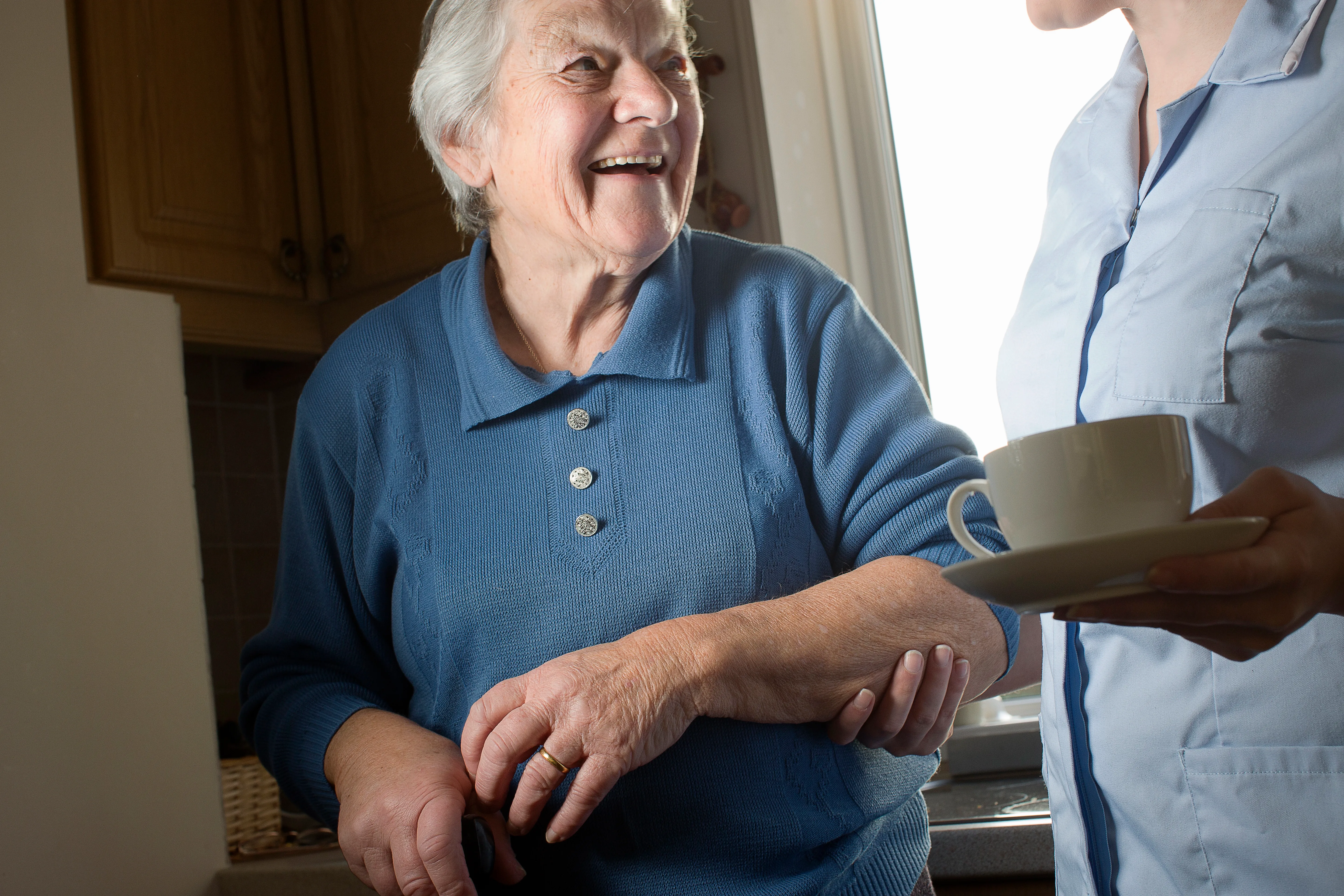 Compassionate caregiver supporting an elderly person at home in Annandale with cup of tea